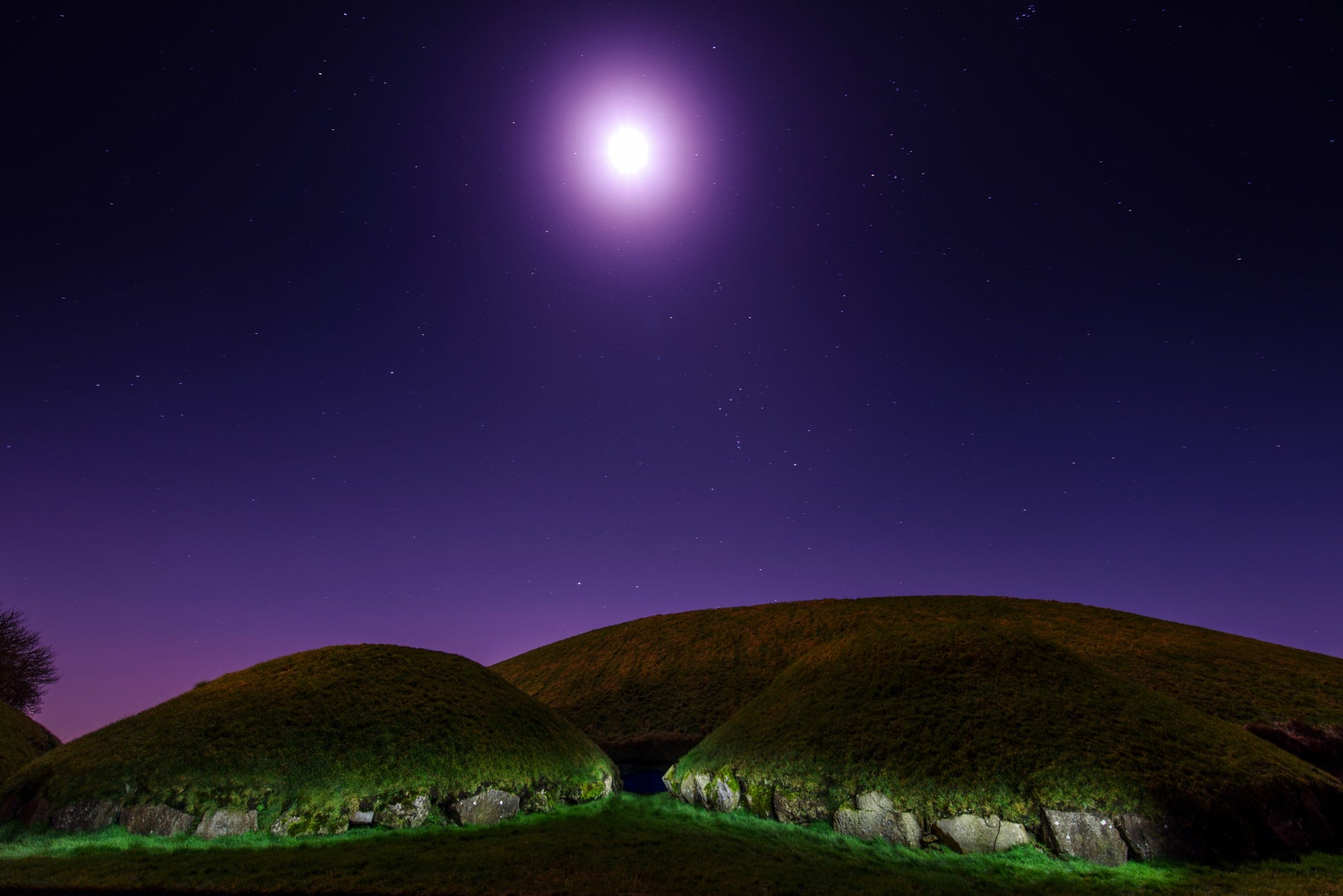 Orion carries the moon over Knowth in Meath Ireland